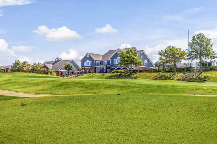 Golf driving range surrounded by lush greenery at Timberlinks at Denton Apartments