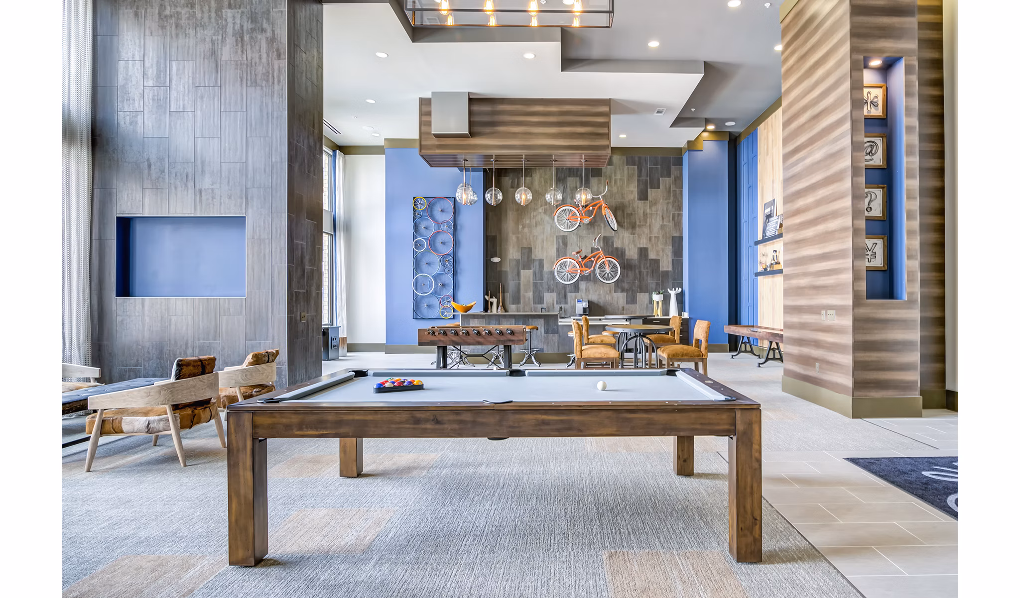 Game room with pool table and lounge seating at One Riverwalk Apartments