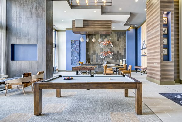 Game room with pool table and lounge seating at One Riverwalk Apartments