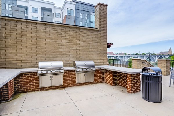 Outdoor grill area with modern seating at One Riverwalk Apartments, offering a perfect spot for community gatherings and relaxation