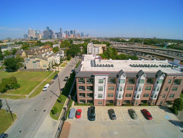 Aerial view showcasing luxury apartments and parking in a vibrant residential area with a city skyline