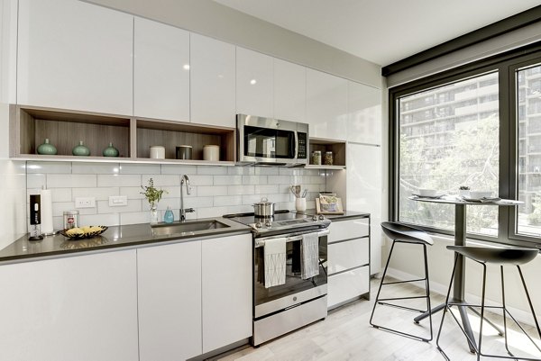 Modern kitchen with granite countertops and stainless steel appliances at Sonnet Apartments