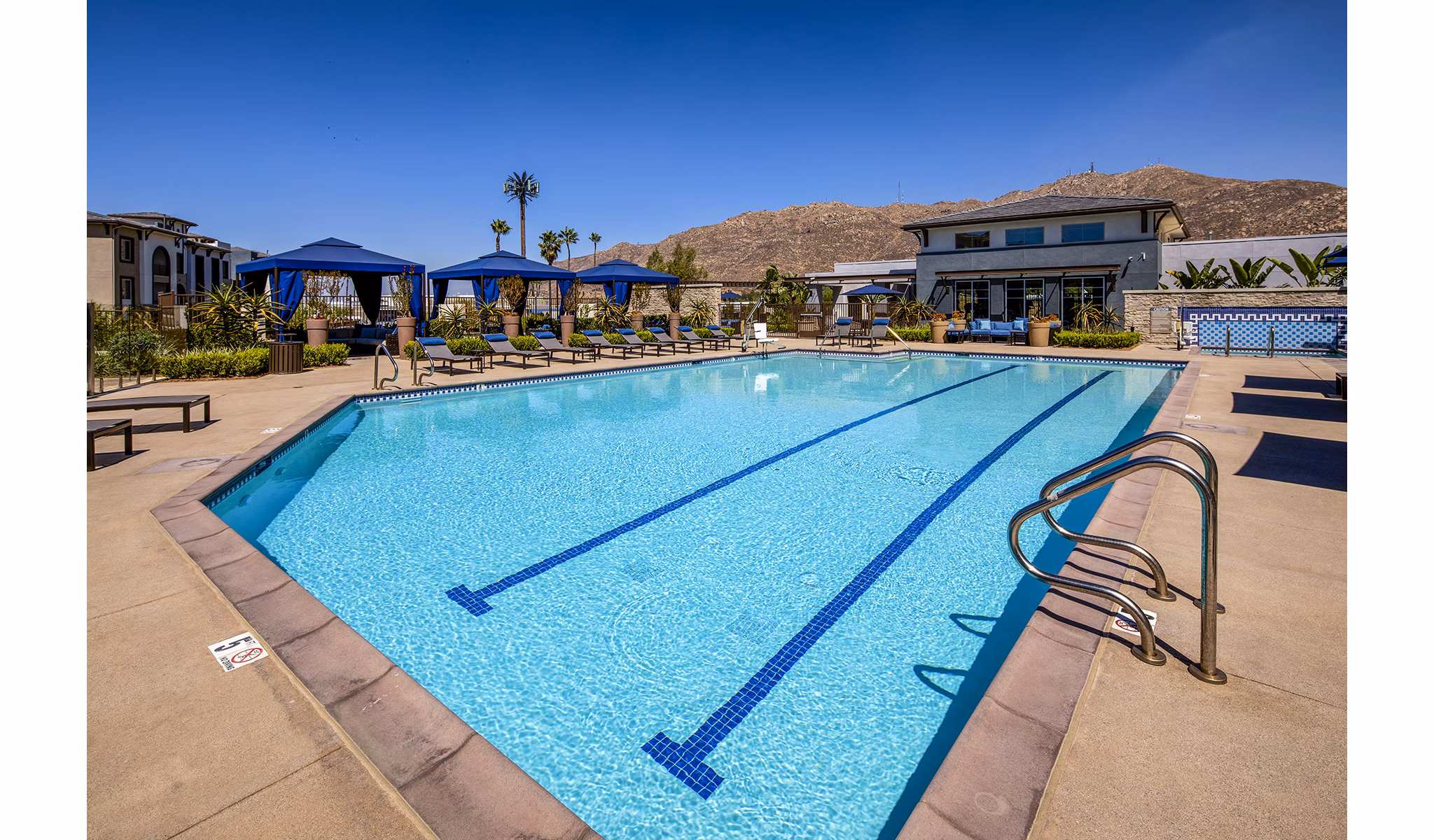Outdoor pool area with lounge seating at Core at Sycamore Highlands, luxury apartments by Greystar in a serene setting