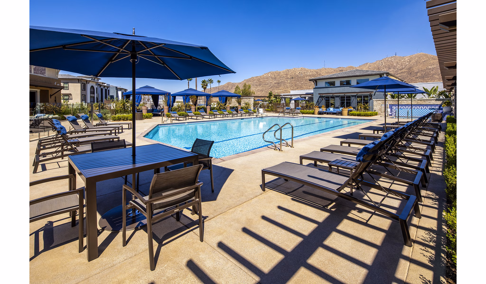 Resort-style pool with lounge chairs at Core at Sycamore Highlands apartments