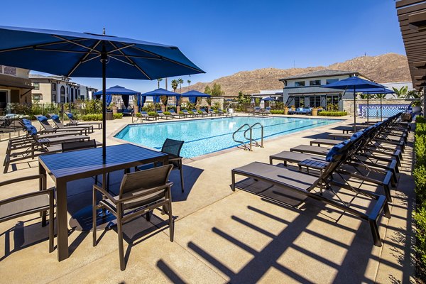 Resort-style pool with lounge chairs at Core at Sycamore Highlands apartments