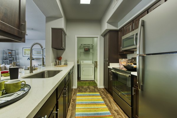 Modern kitchen with stainless steel appliances at Galleria Palms Apartments, luxury living space designed for comfort and style