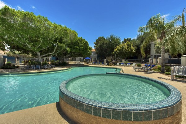 Resort-style pool at Galleria Palms Apartments featuring lush landscaping and comfortable lounge areas