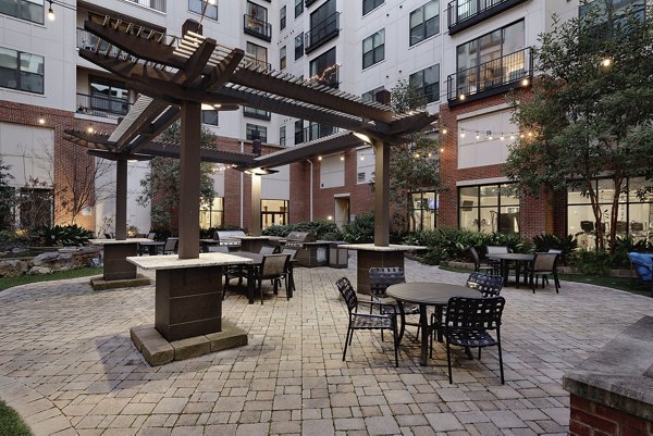 Outdoor grill area with seating at The Standard at Athens Apartments