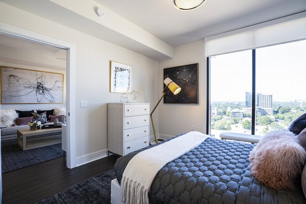 Bedroom with modern decor and city views at Ascent Midtown Apartments