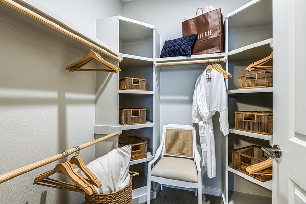 Walk-in closet with ample shelving in bedroom at Overture Dr Phillips Apartments