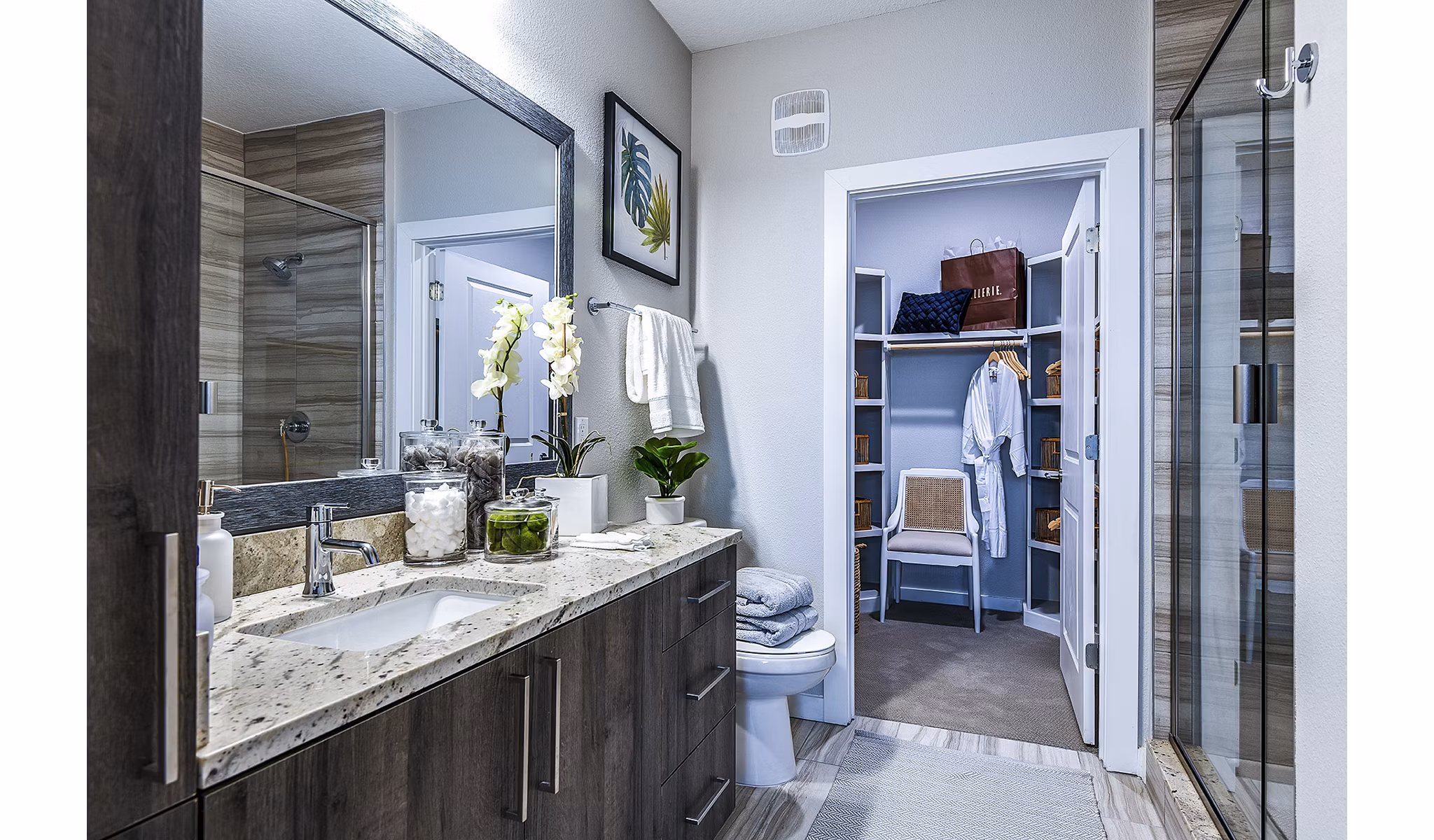 Bathroom with luxurious marble tiles and glass-enclosed shower at Overture Dr Phillips Apartments