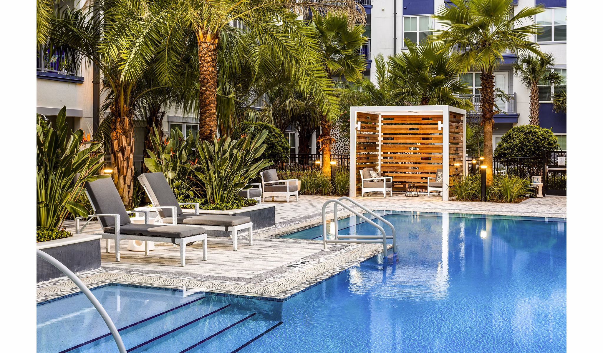 Resort-style pool with lounge chairs at Overture Dr Phillips Apartments