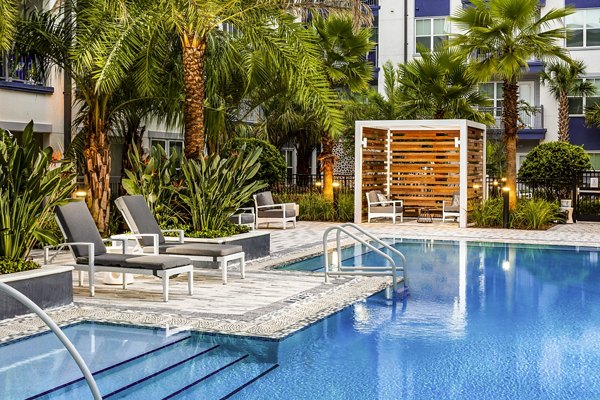 Resort-style pool with lounge chairs at Overture Dr Phillips Apartments