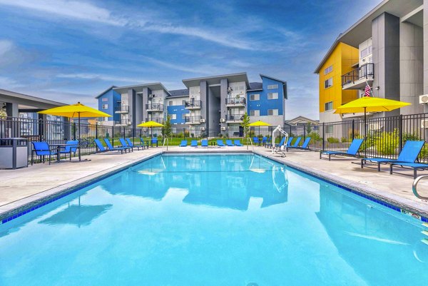 Luxurious pool area with sun loungers at The Northern at Coeur d'Alene Place Apartments offering a relaxing retreat in nature
