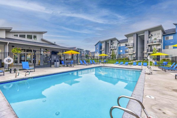 Luxurious outdoor pool at The Northern at Coeur d'Alene Place Apartments with sun loungers and resort-style ambiance