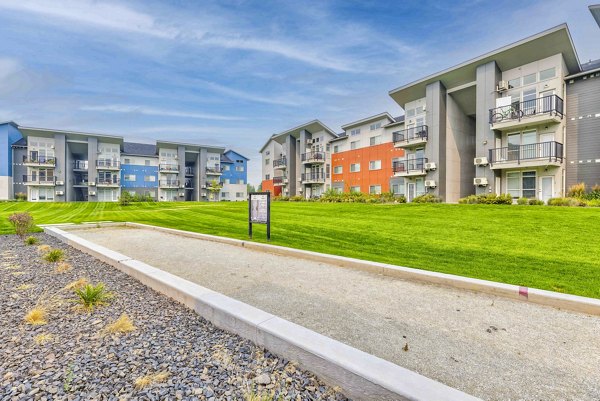 Bocce court surrounded by lush landscaping at The Northern at Coeur d'Alene Place Apartments