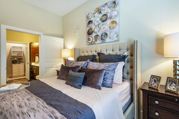 Cozy bedroom with modern decor at Hardy Yards Apartment Homes, featuring stylish bedding and natural lighting for a relaxing atmosphere