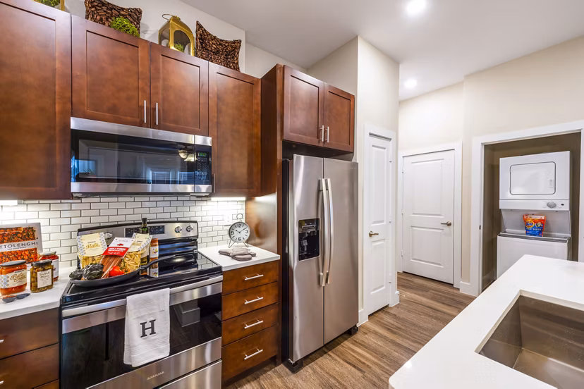 Modern kitchen with granite countertops and stainless steel appliances in Hardy Yards Apartment Homes