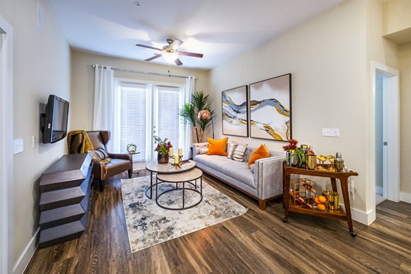 Spacious living room with modern decor and large windows in Hardy Yards Apartment Homes