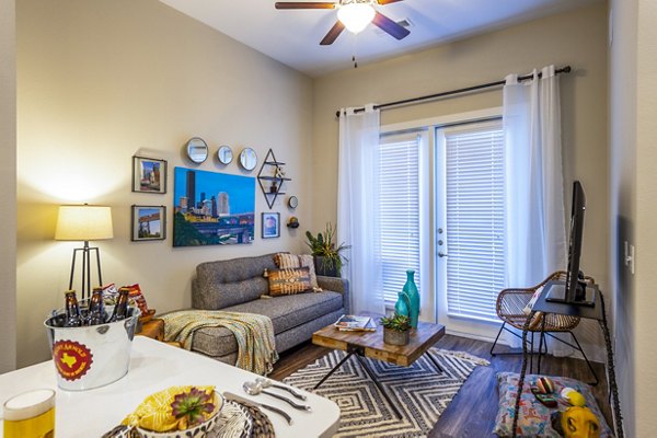 Modern living room with plush seating and large windows at Hardy Yards Apartment Homes