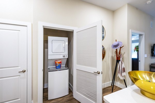 Laundry room with modern appliances at Hardy Yards Apartment Homes