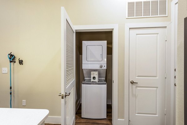 Modern laundry room with energy-efficient washers and dryers at Hardy Yards Apartment Homes in Houston