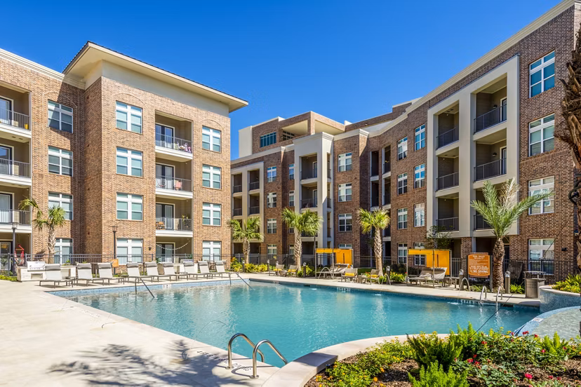 Outdoor pool with modern lounge chairs at Hardy Yards Apartment Homes, offering leisure and relaxation