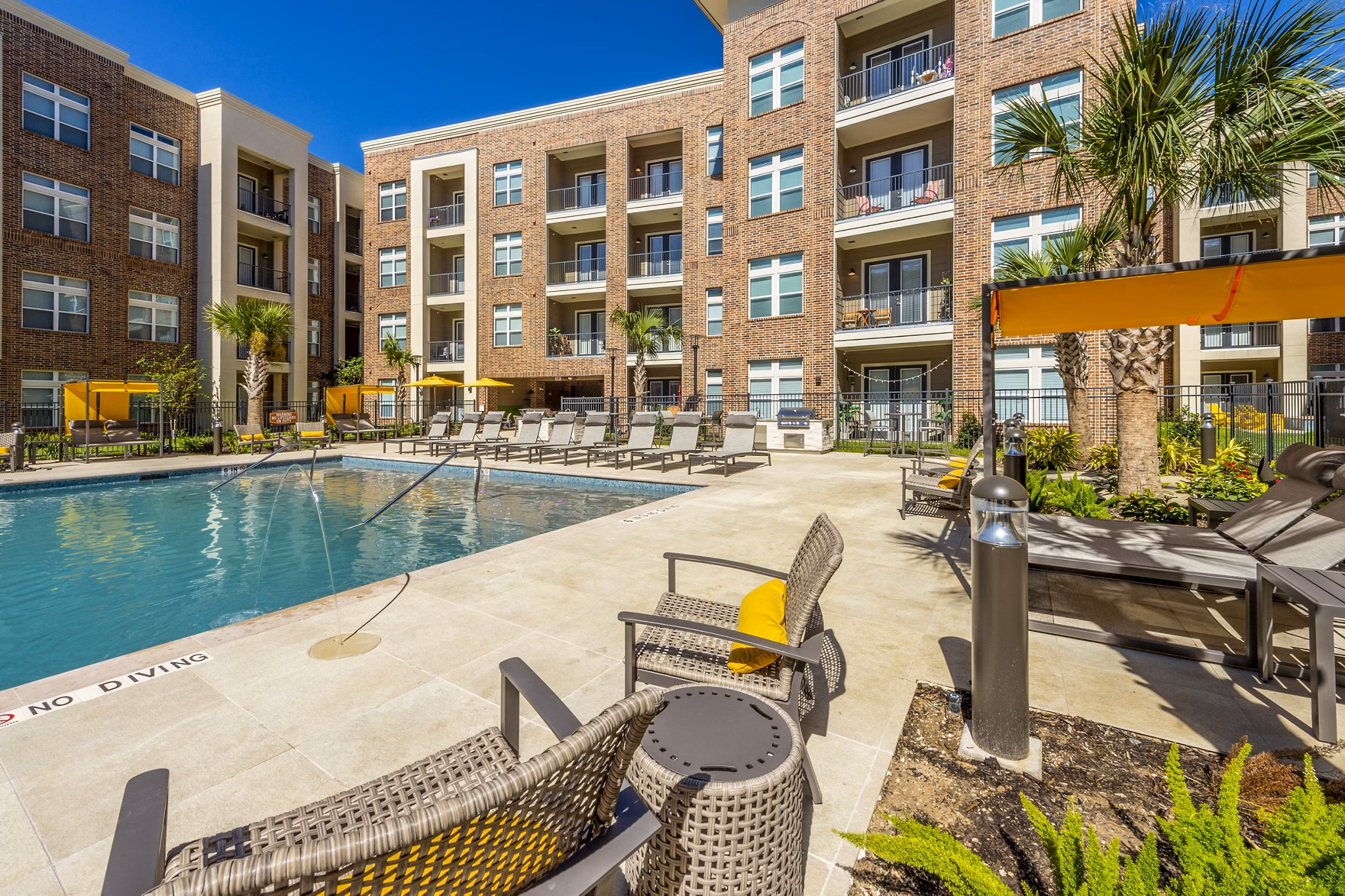 Modern pool area with stylish lounge chairs at Hardy Yards Apartment Homes, ideal for relaxation and leisure activities