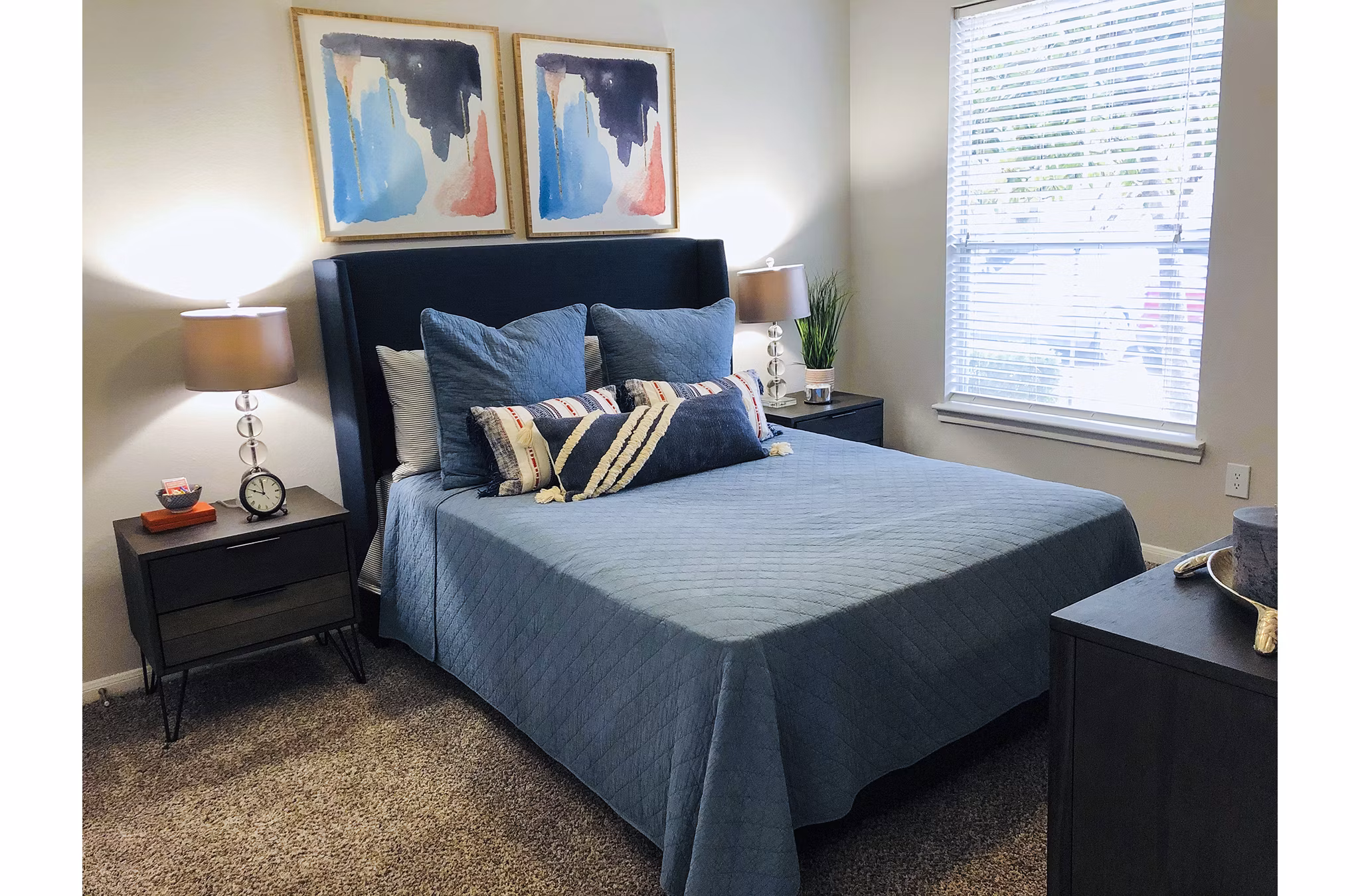 Cozy bedroom with modern decor and large windows at Breakers at Windmill Lakes Apartments