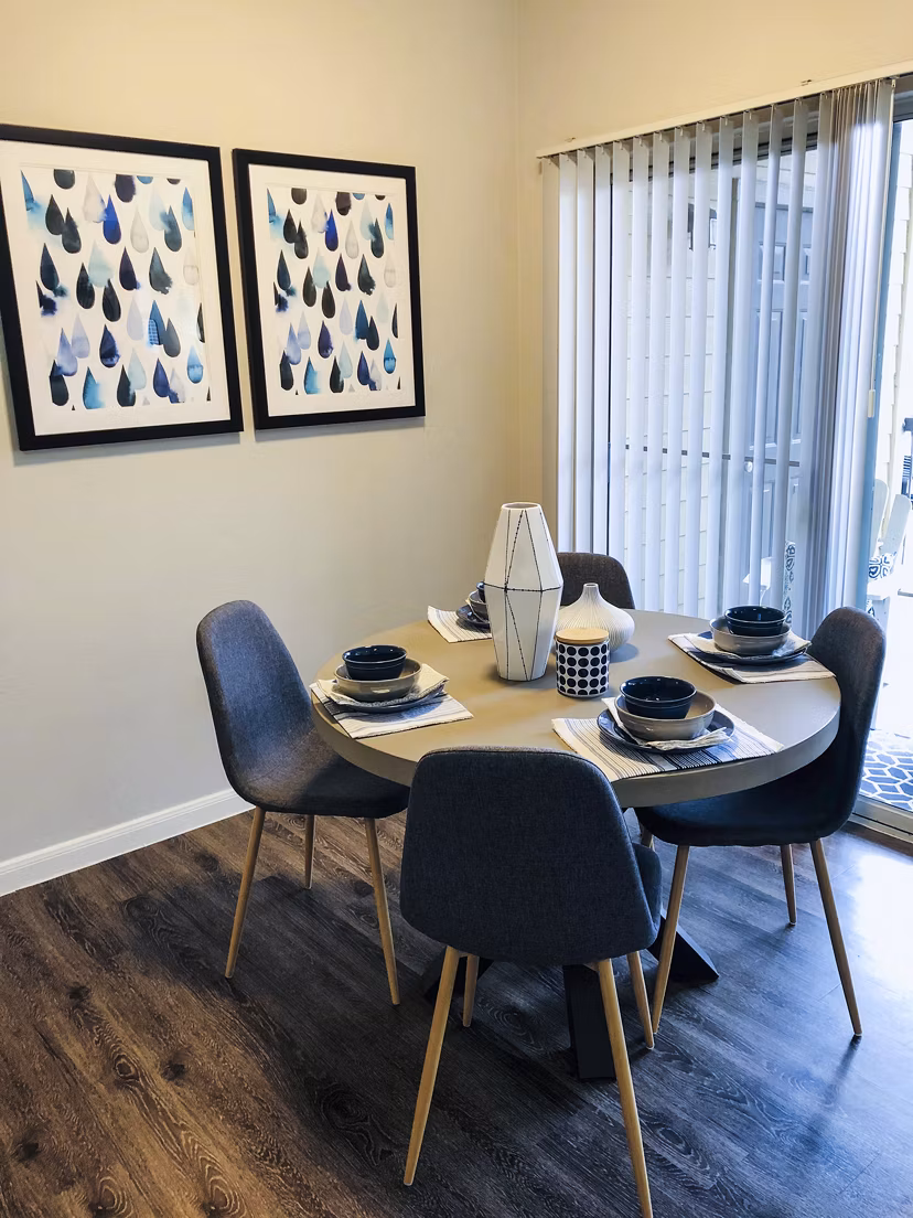 Dining room with elegant chandelier and modern decor at Breakers at Windmill Lakes Apartments