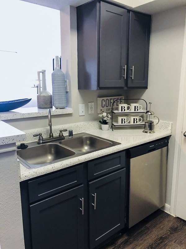 Modern kitchen with sleek countertops and stainless steel appliances in Breakers at Windmill Lakes Apartments