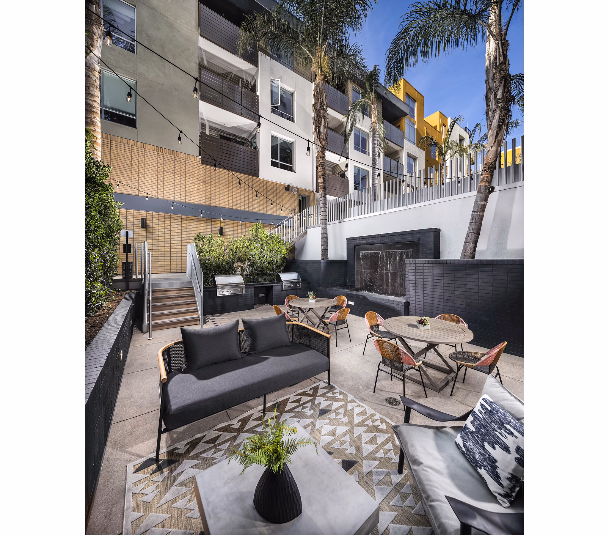 Grill area and patio at Alaya Hollywood Apartments featuring outdoor seating and BBQ stations for entertainment
