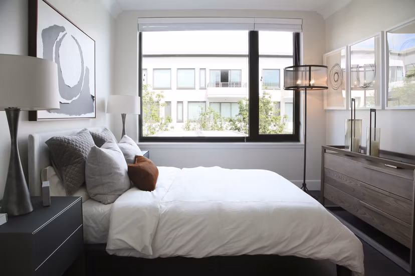 Bedroom with modern decor and plush bedding at Grey House Apartments, offering luxury living in a premier Greystar community
