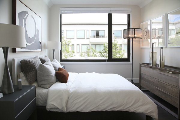 Bedroom with modern decor and plush bedding at Grey House Apartments, offering luxury living in a premier Greystar community