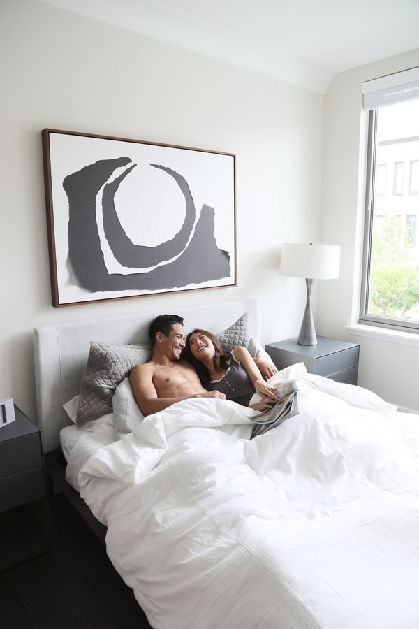 Cozy bedroom with modern decor at Grey House Apartments, featuring luxurious bedding and natural light