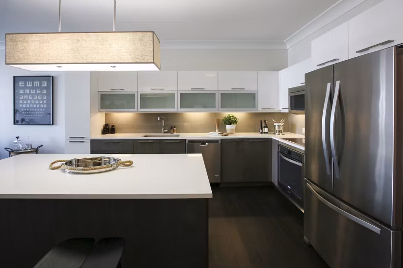 Modern kitchen with stainless steel appliances and island at Grey House Apartments