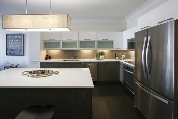 Modern kitchen with stainless steel appliances and island at Grey House Apartments