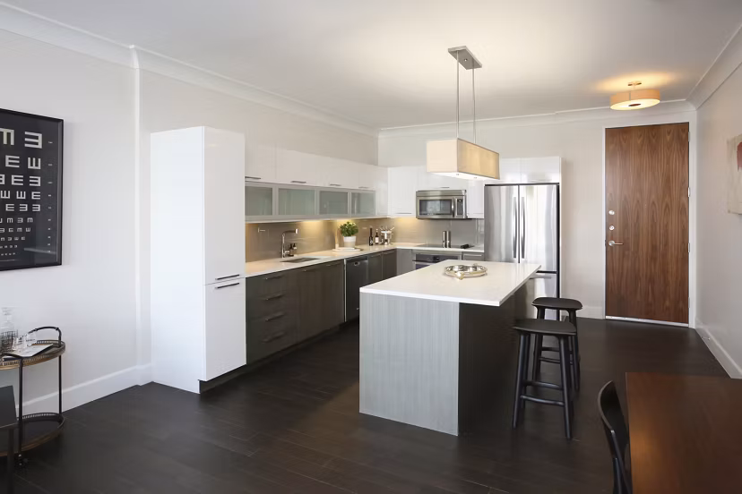 Contemporary kitchen featuring marble countertops and stainless steel appliances in Grey House Apartments