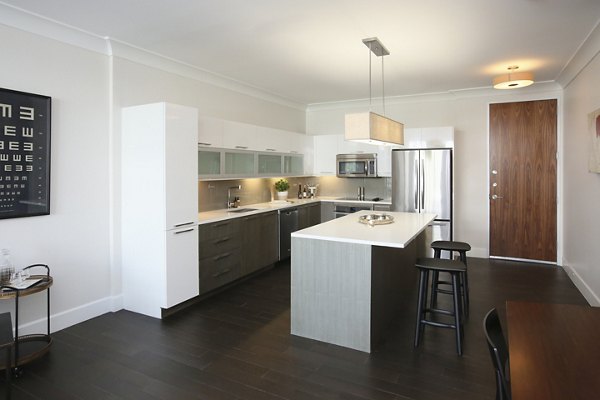 Contemporary kitchen featuring marble countertops and stainless steel appliances in Grey House Apartments
