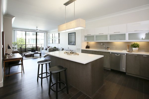 Modern kitchen featuring stainless steel appliances and granite countertops at Grey House Apartments