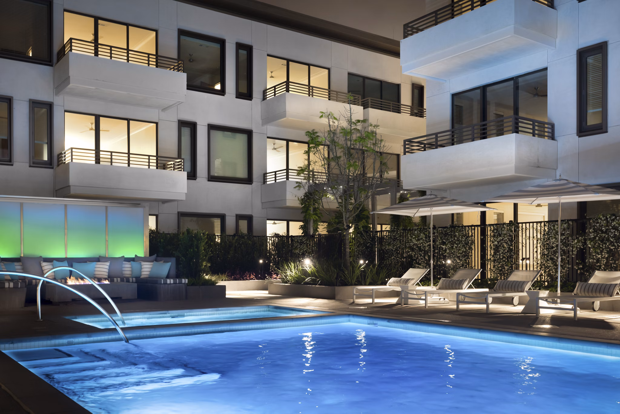 Modern pool with lounge chairs at Grey House Apartments, offering a refreshing retreat in the heart of luxury living