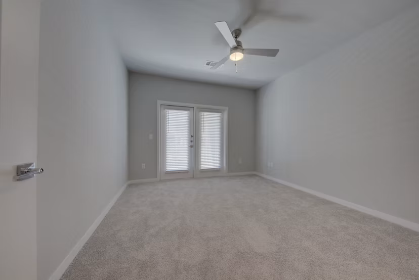 Bedroom featuring elegant decor and large windows at Tacara Westpointe Village Apartments