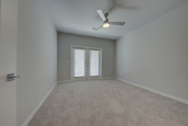 Bedroom featuring elegant decor and large windows at Tacara Westpointe Village Apartments