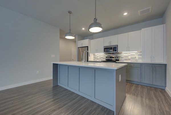 Modern kitchen with stainless steel appliances at Tacara Westpointe Village Apartments in a luxury Greystar community
