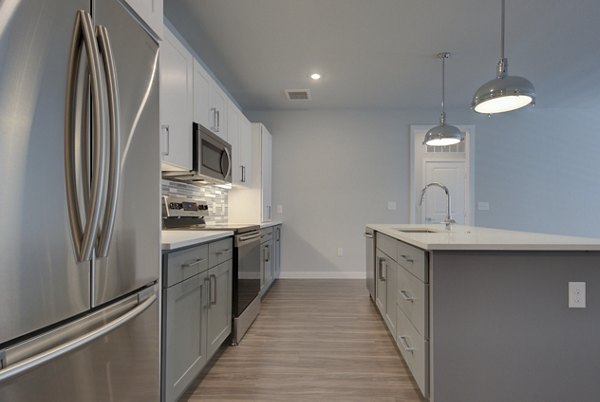 Modern kitchen featuring stainless steel appliances and granite countertops at Tacara Westpointe Village Apartments