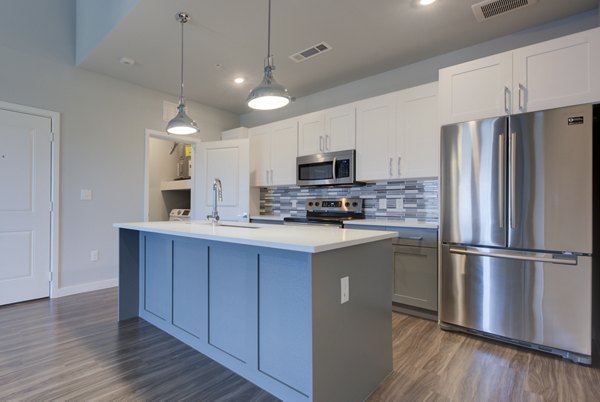 Modern kitchen with granite countertops and stainless steel appliances at Tacara Westpointe Village Apartments