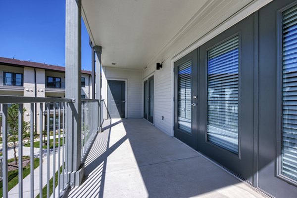 Patio with cozy seating and lush landscaping at Tacara Westpointe Village Apartments