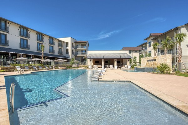 Resort-style pool with sun loungers at Tacara Westpointe Village Apartments