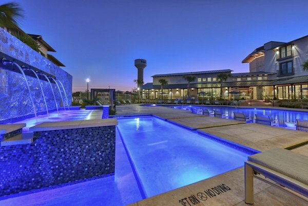 Resort-style pool with sun loungers at Tacara Westpointe Village Apartments, offering luxury amenities for relaxation and recreation