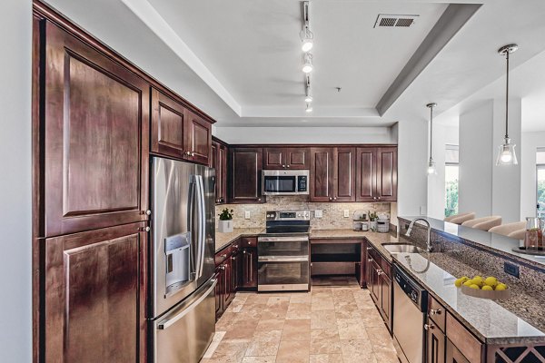 Modern kitchen with sleek appliances and quartz countertops at The Residence at SouthPark Apartments